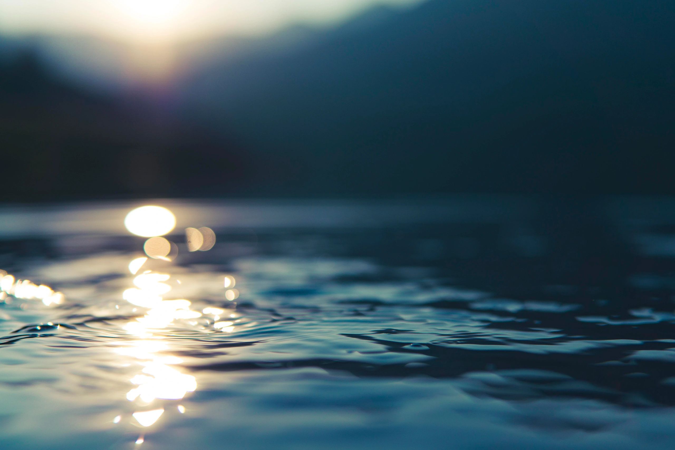 Sunlight reflecting on rippling water surface during dusk.