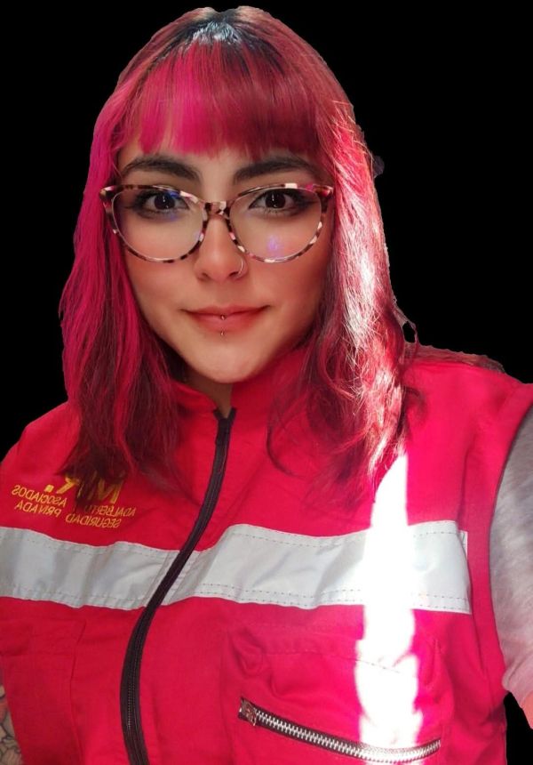 Young woman with pink hair and glasses wearing a red safety vest.