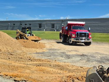Construction site with machinery and a red truck under blue sky.