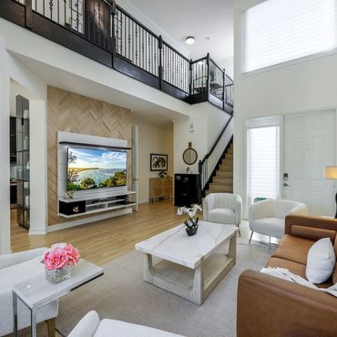 Bright modern living room with leather sofa and large TV.