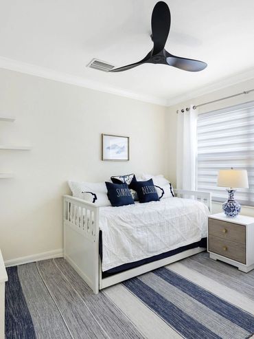 Bright and cozy bedroom with white furniture and blue accents.