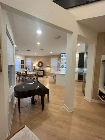 Spacious living area with a black grand piano and modern dining setup.