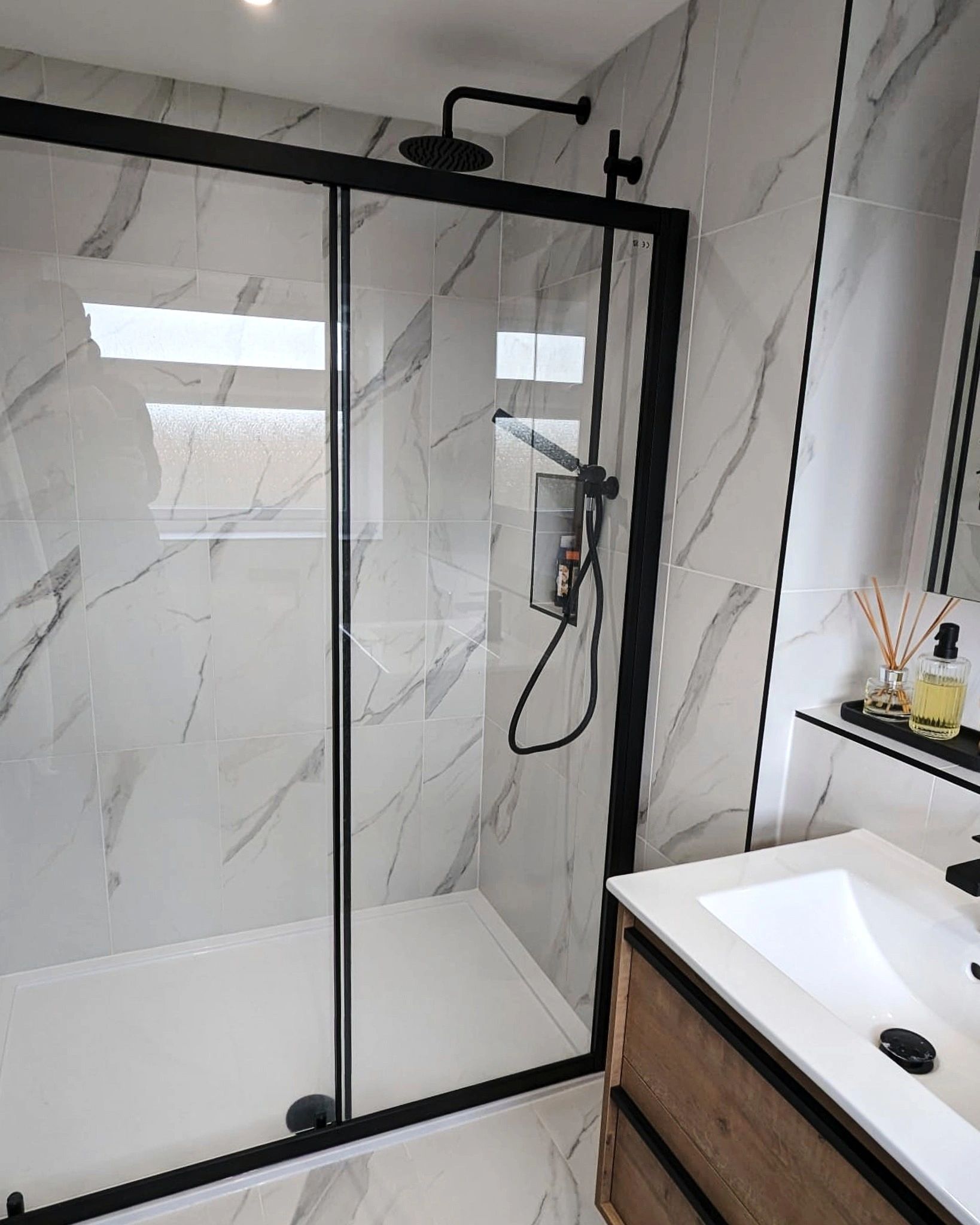 New ensuite featuring black fittings and marble style tiling.