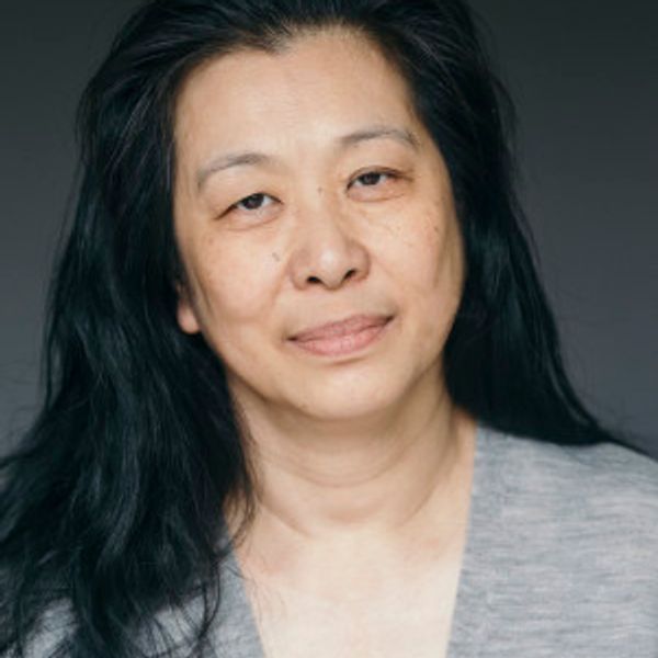 Portrait of a middle-aged woman with long black hair and a gentle smile.