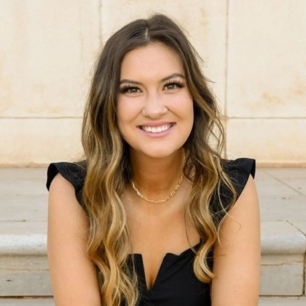 Smiling woman with wavy hair and black top.
