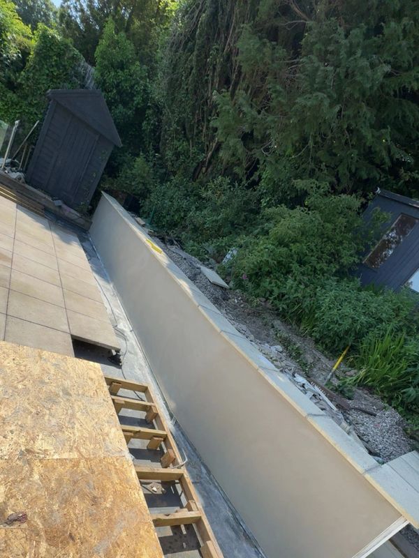A long, empty pool under construction in a backyard garden.