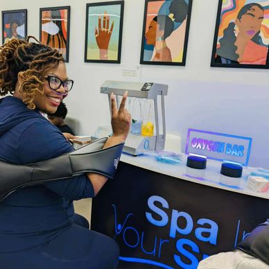 Smiling woman at a spa oxygen bar showing a peace sign.