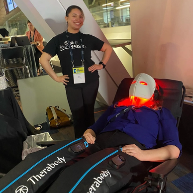 Woman relaxing with Therabody recovery gear and a red light therapy mask.