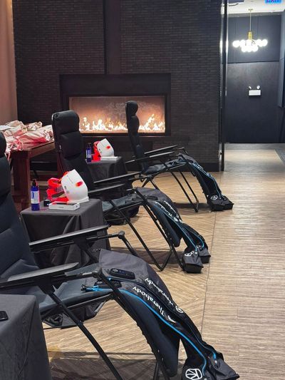 Relaxing chairs with therapy boots near a modern fireplace.