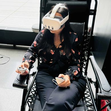 Woman relaxing on a recliner using a VR headset and controllers.
