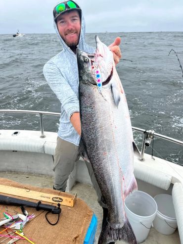 Man holding a large fish on a boat.