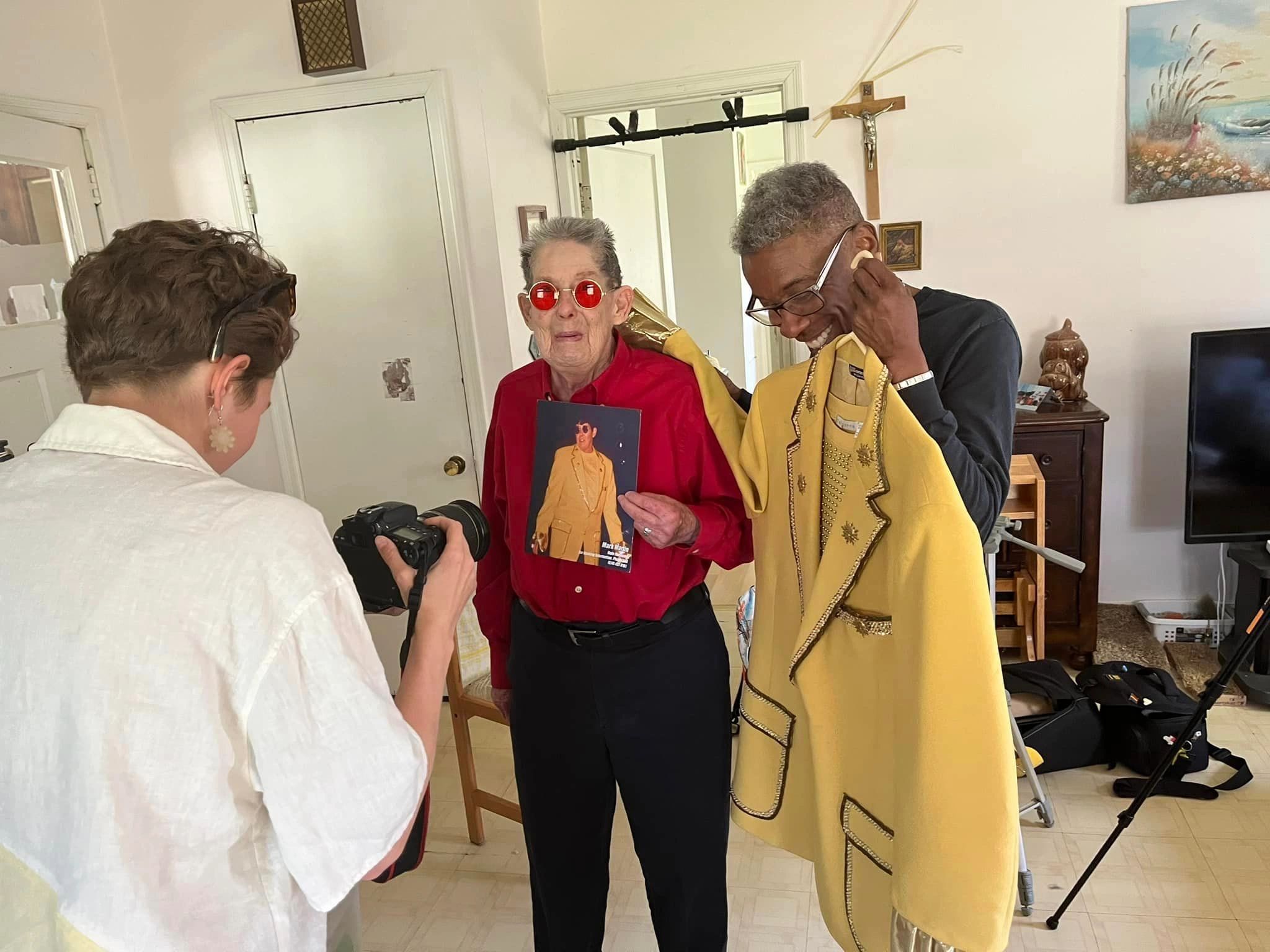 Videographer photographing drag king Mark Martin and filmmaker LuSter Singleton with costume.