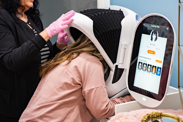 Woman getting an AI skin analysis with the Opatra Dome device in Dartmouth Nova Scotia