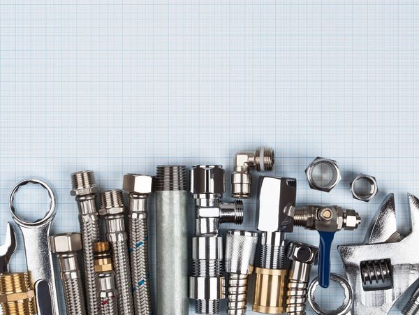 Plumbing supplies on top of blue graph paper.