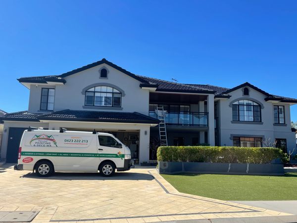 Large modern house with painting service van outside.