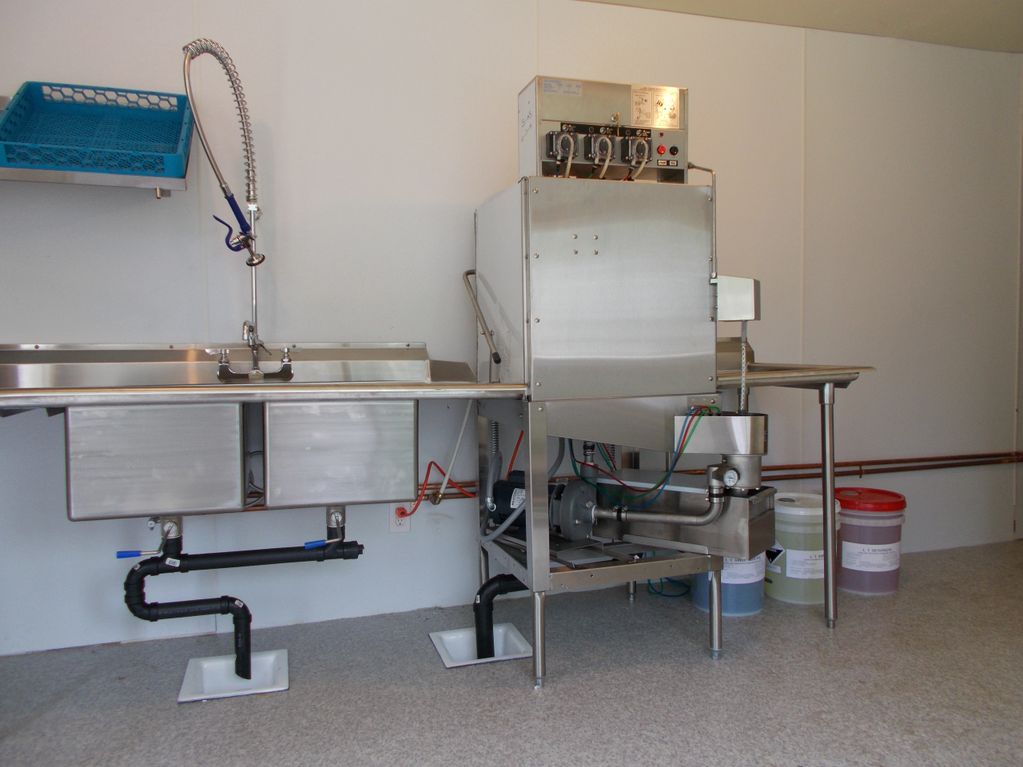 Commercial kitchen setup project at Doe Bay Resort, Olga WA: dishwasher, shelves, table, and sink