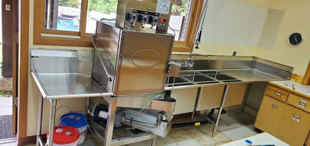 Commercial kitchen setup project at Orcas Center, Eastsound WA: dishwasher, table, and sink