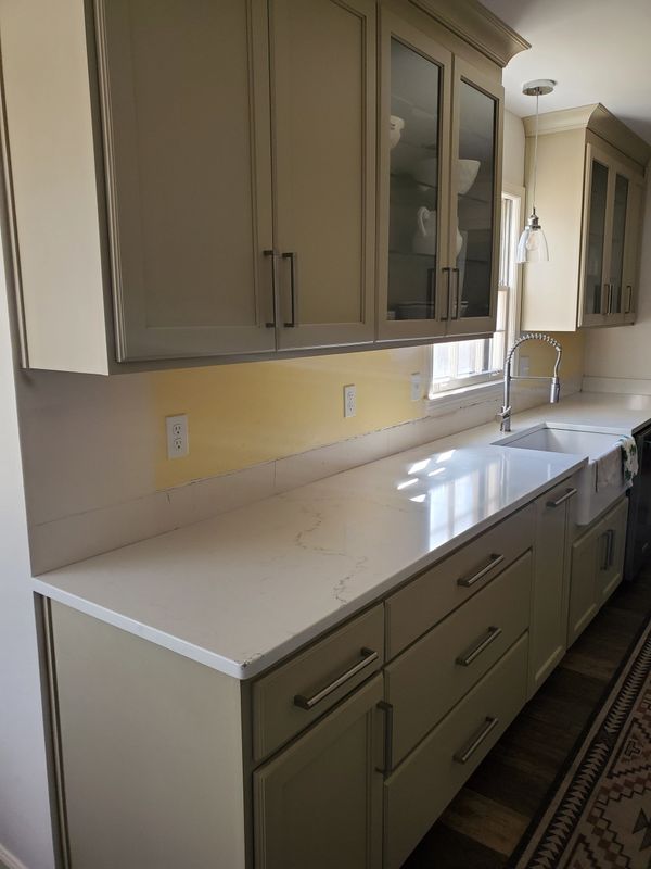 white kitchen cabinets with glass front and yellow walls and white quartz countertop