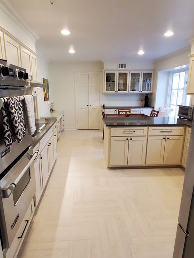 white kitchen cabinets and quartz countertops with herringbone large format marble look tile