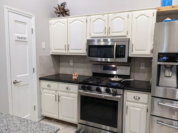 stainless steel stove and microwave with grey tile backsplash
