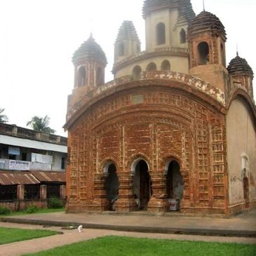 Ancient terracotta temple with intricate carvings and domed towers.