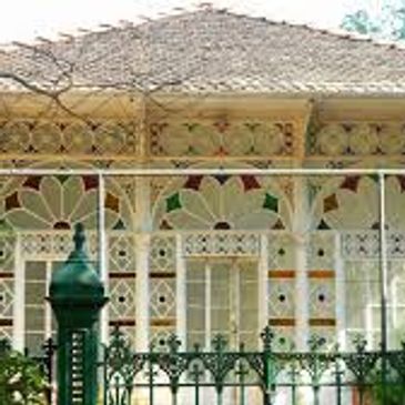 Ornate Victorian-style house with detailed woodwork and colorful glass windows.