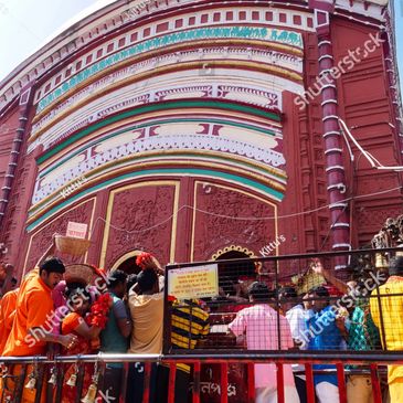 People gathered at a colorful temple entrance in India for worship.