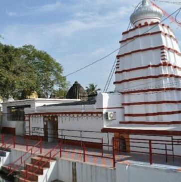 White and red Hindu temple with a stepped entrance and dome.
