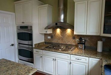 Modern kitchen with white cabinets, granite countertops, and stainless steel appliances.