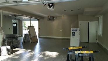 A spacious garage with packed furniture and a refrigerator.