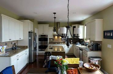 Spacious kitchen with white cabinets and granite countertops.