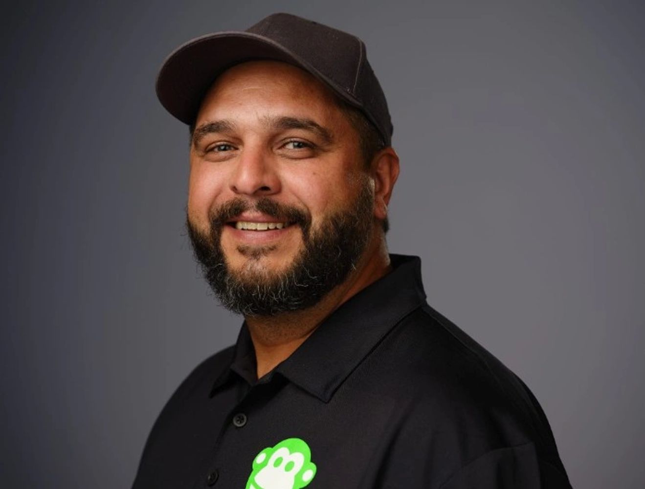 Junk Monkees owner in a black company polo and cap.