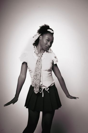 Young woman posing in a skirt and tie.