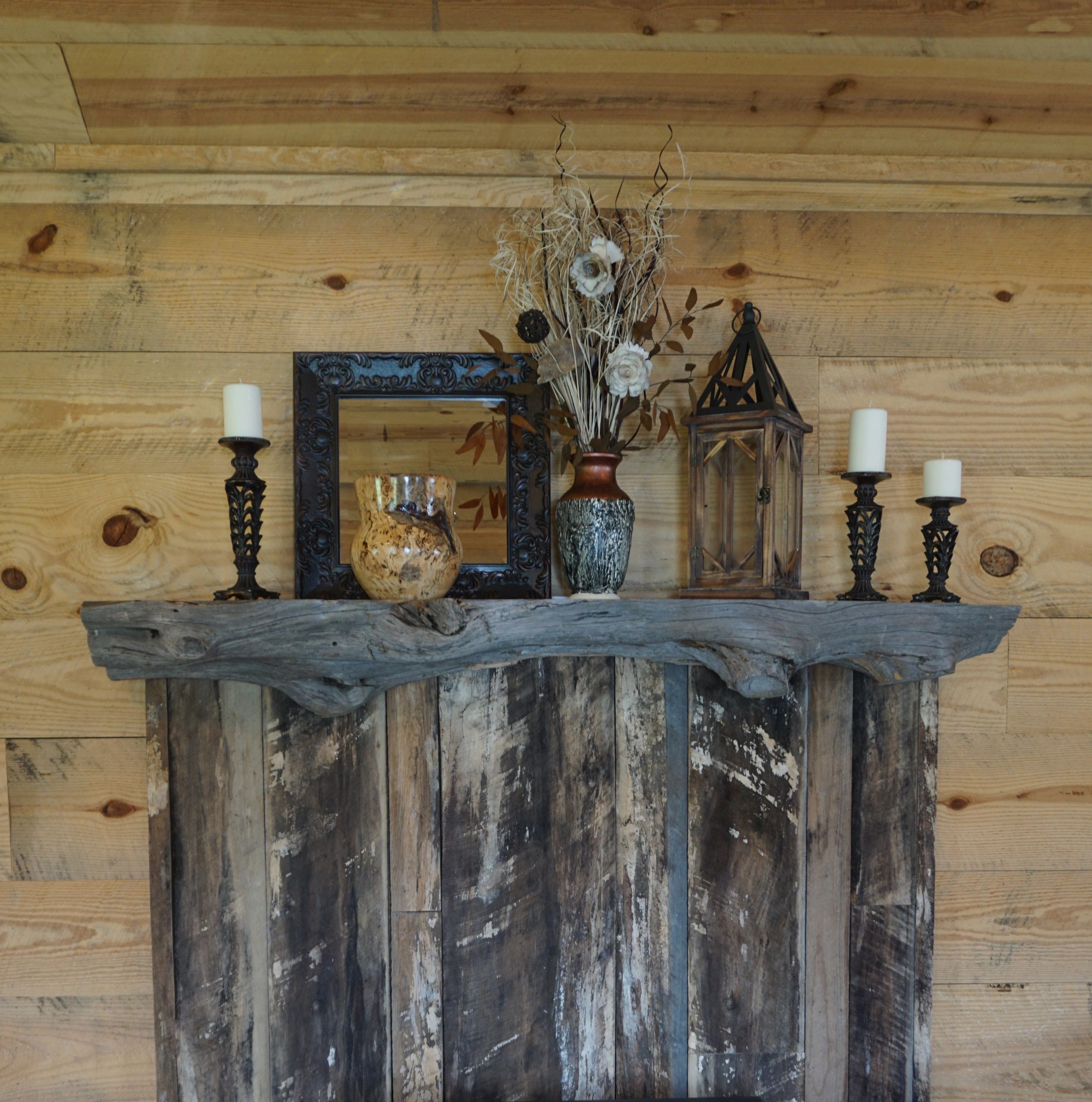 Rustic reclaimed barn wood paneling with a unique cedar fireplace mantle