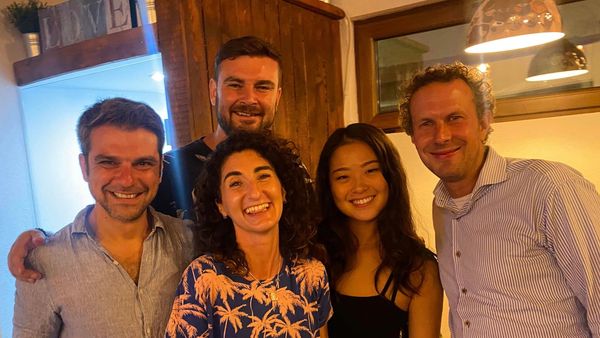 Group of 5 cowokers smiling and posing for a photo in Altspace Coworking in Bansko Central location.