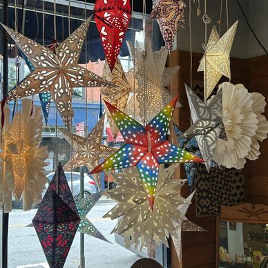 Colorful and patterned paper star lanterns hanging indoors.