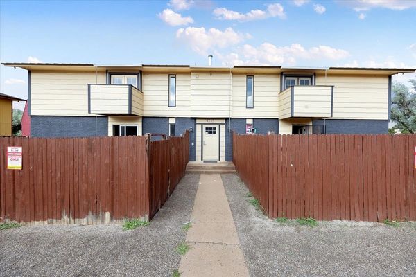 Two-story apartment building with wooden fences and balconies.