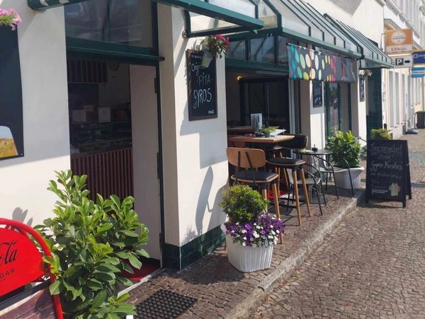 Gemütliches Straßencafé mit Sitzgelegenheiten und Pflanzen.