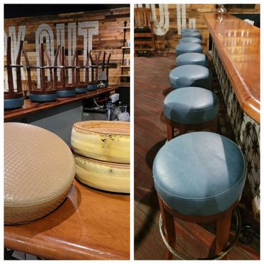 Bar stools with worn cushions and a row of restored blue stools at a wooden bar.