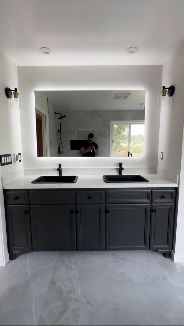 Quartz Countertop with top mounted bathroom sinks on repainted cabinets and lightening mirror