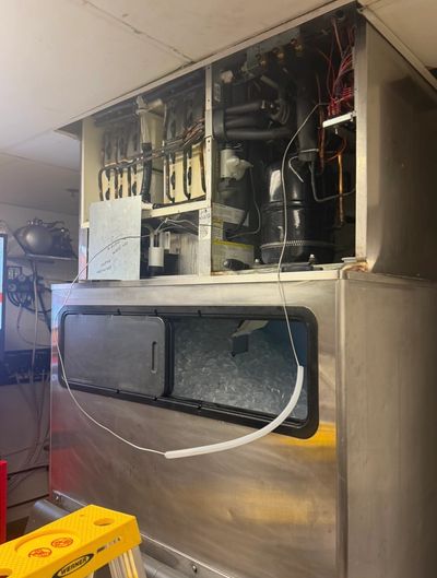 Large commercial ice machine with exposed mechanical components.