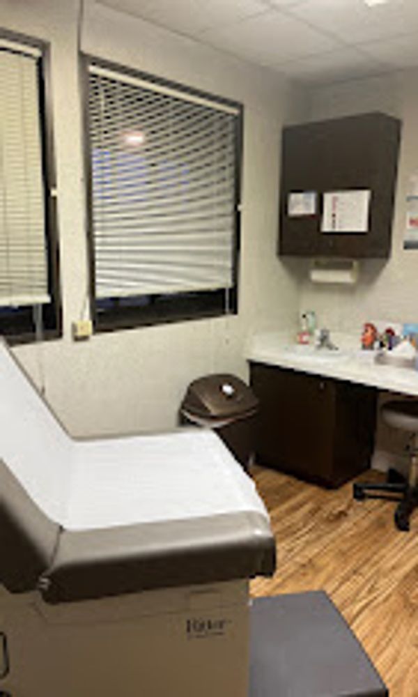 A clean medical examination room with an exam table and medical supplies.