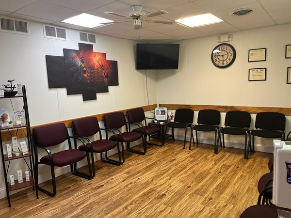 A clean, modern waiting room with chairs and wall art.