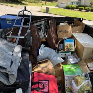 A truck bed filled with various packed boxes and household items.