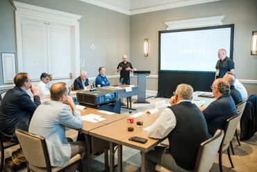 Business meeting with presentation on COMPLYL in a conference room.