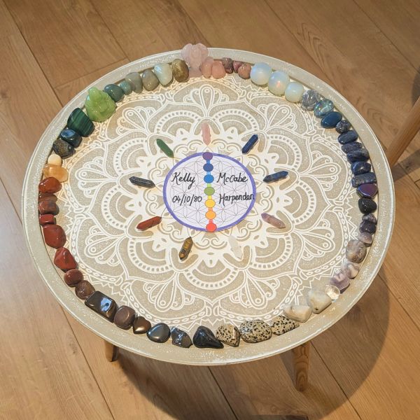 Colorful gemstones arranged in a circle on a decorative table with a name card.