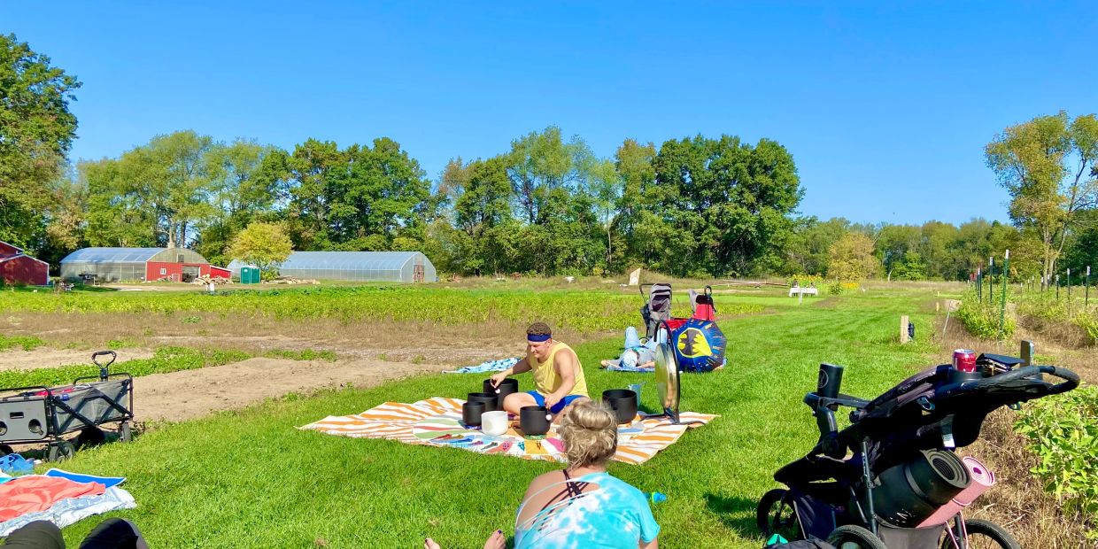 People relaxing on a grassy field under clear blue sky.