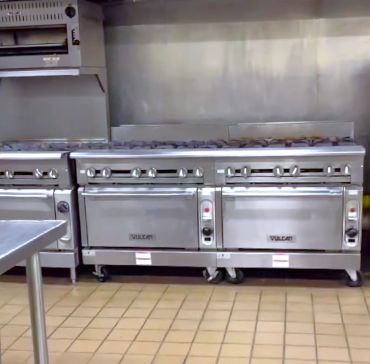 Commercial kitchen stoves with ovens.