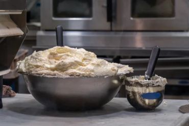 Two bowls filled with dough or batter and black spatulas.
