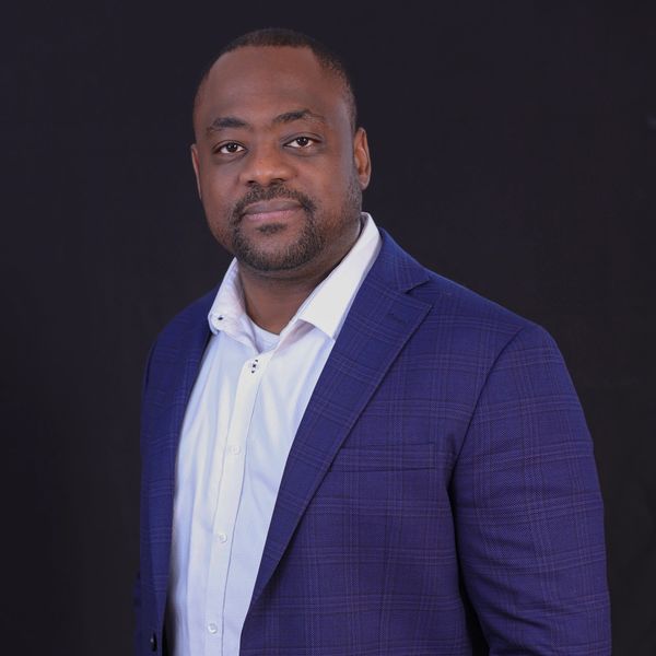 Man in blue blazer and white shirt posing confidently is a consultant.